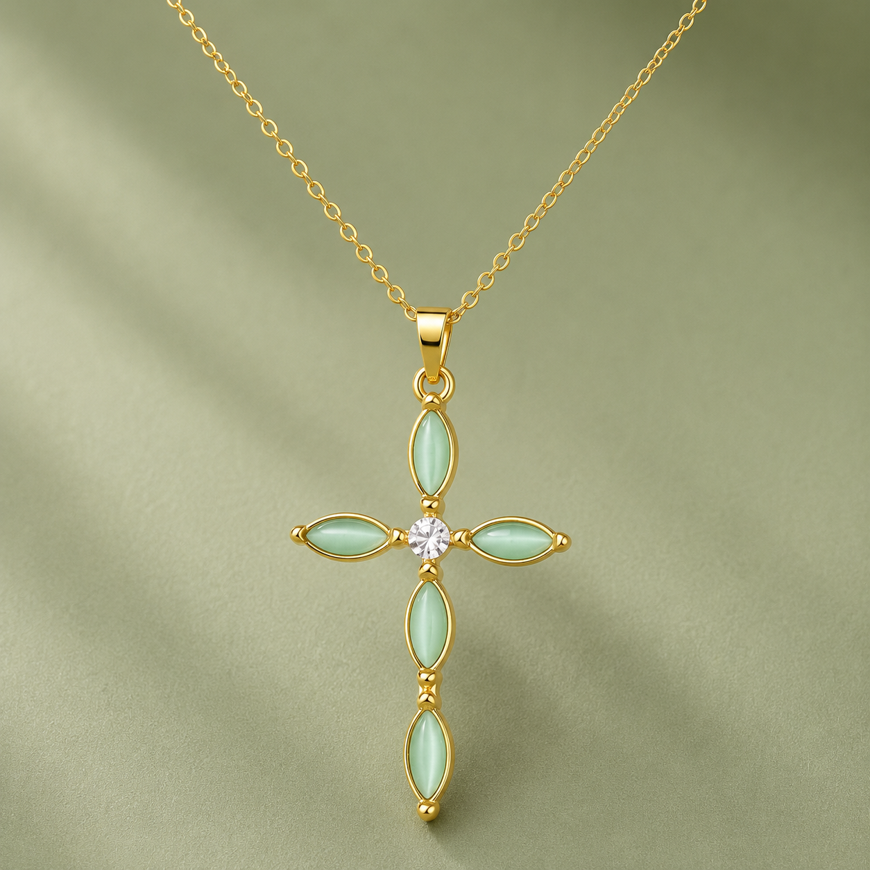Cat's Eye stone cross necklace on a soft sage background
