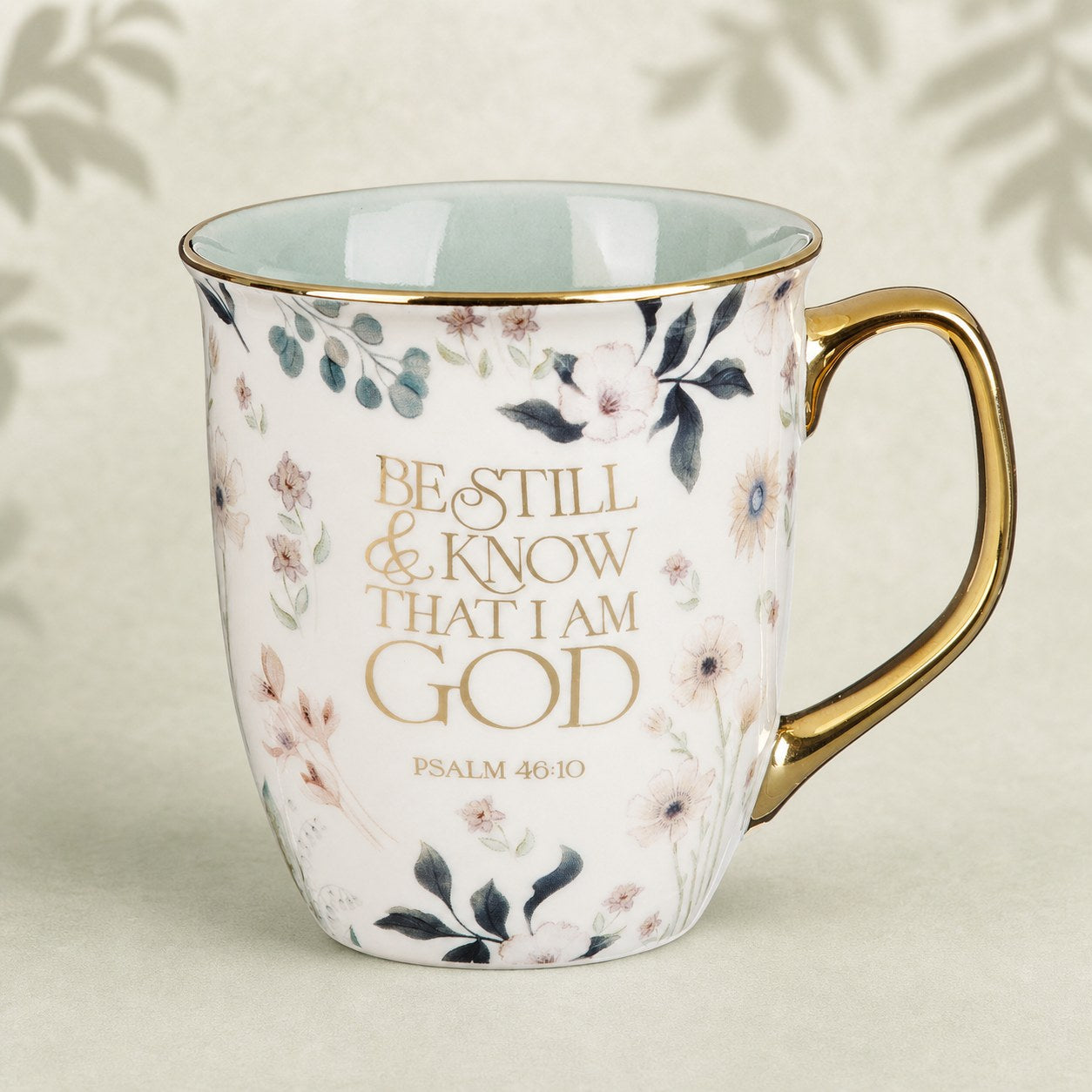 Teal floral Be Still mug on a warm sage and cream background